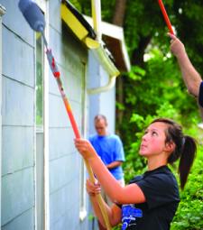 female student painting and voluntering