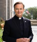 Daniel Hendrickson smiling with hands folded