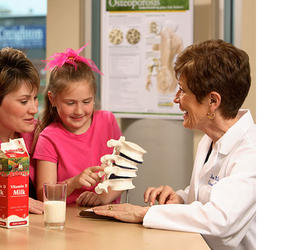 Joan M. Lappe speaking to a young girl and her mother