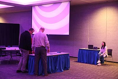 Participants working through the challenges in the Phishing Escape Room with Radlab intern watching