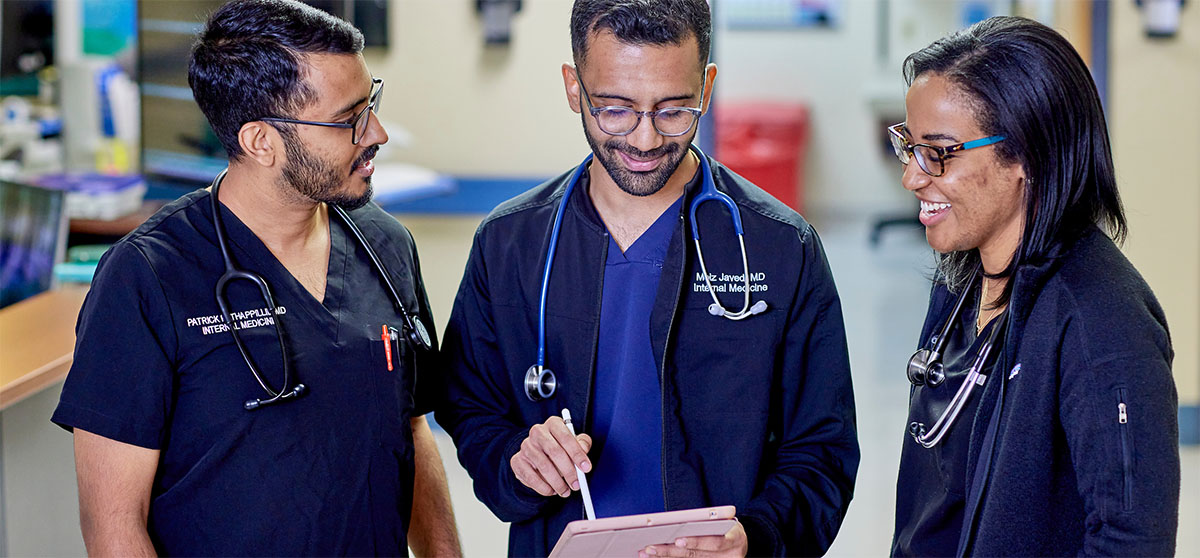 Creighton health professionals examining information in hospital setting.