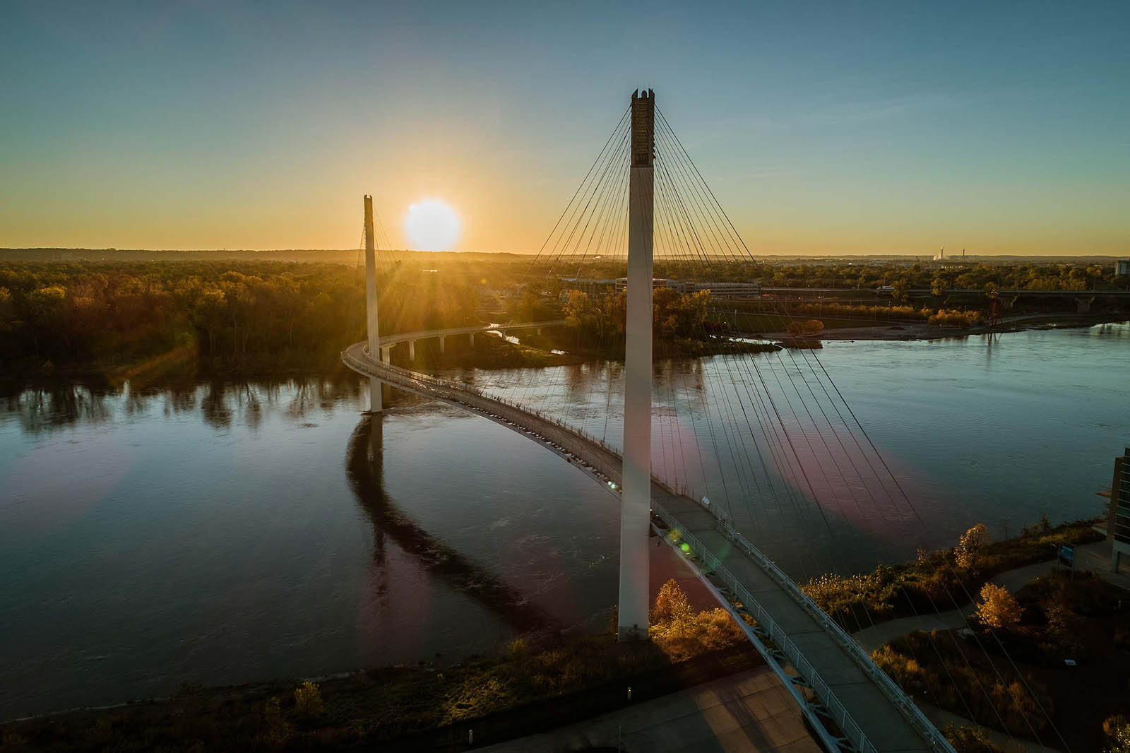 Omaha morning as sun comes up over Missouri River and Kerrey walking bridge.