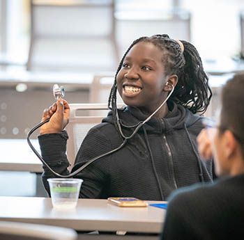 Young person learning about a stethoscope.