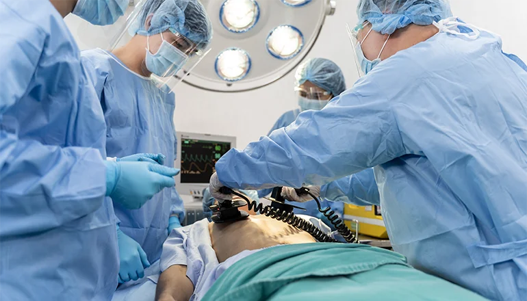 Surgeons using AED on patient