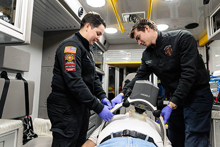 Ava Brandt and Eric Pagnano administering care to patient.