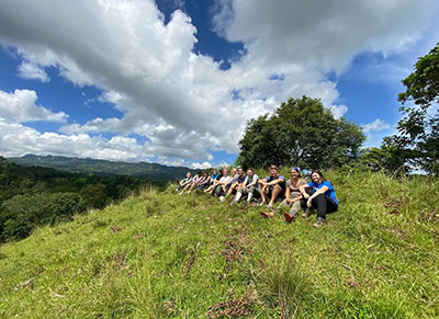 Isabella Brown with fellow students sitting on mountain side in Dominican Republic.