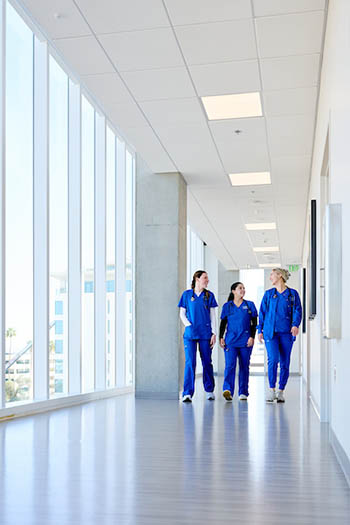 Nursing students walking hallway and chatting.