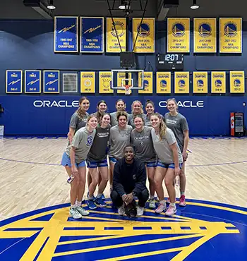 Shack pictured with women's basketball team at Oracle center.