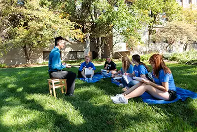 Tom Wong with students outside.