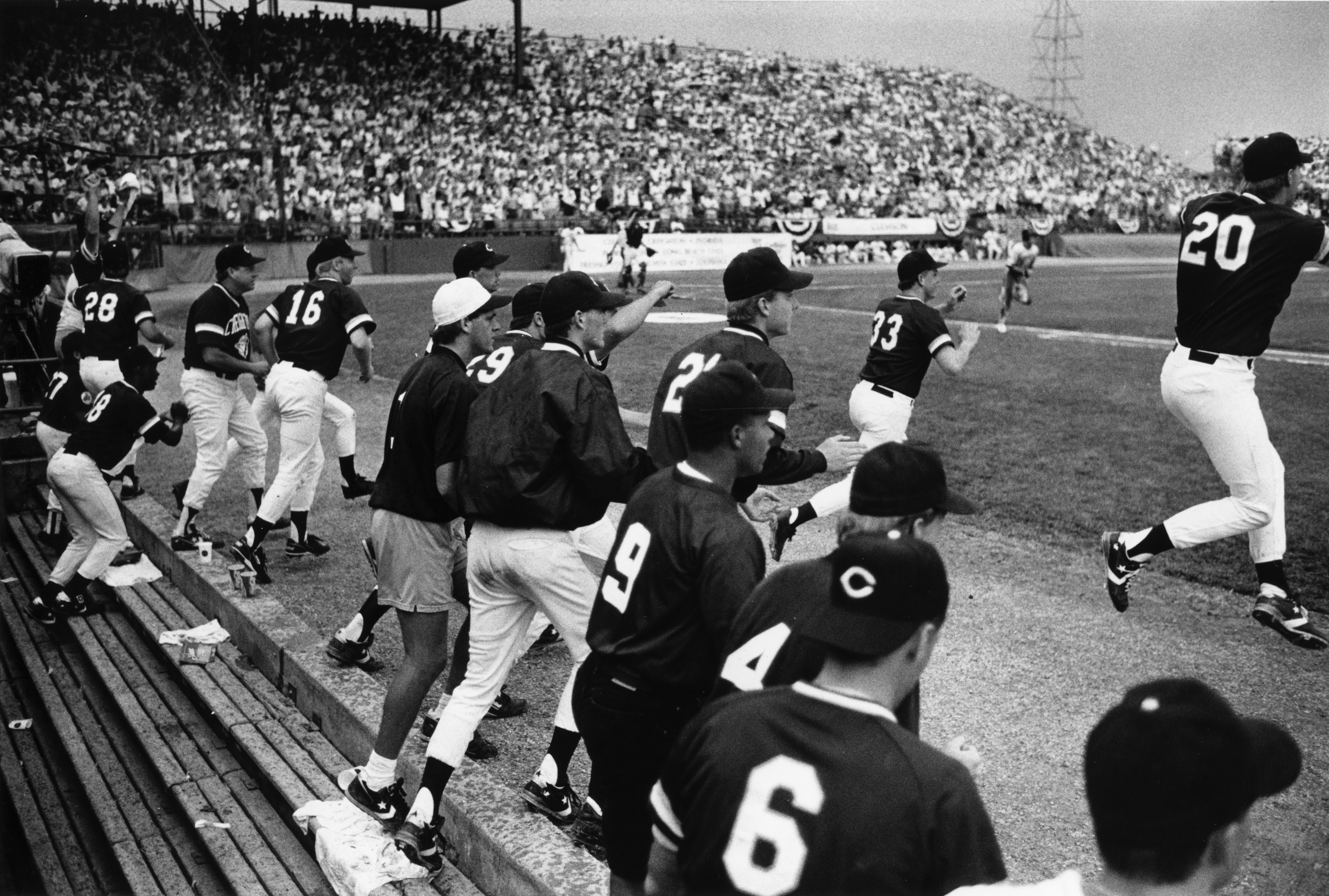 Baseball players running out of the dugout and onto the field.