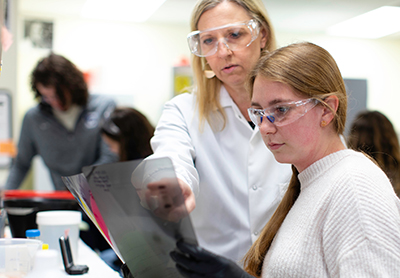 Strauss-Soukup works with students to further lab research.