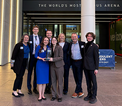 Creighton team poses at the arena with trophy.