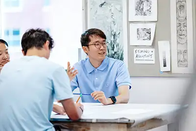 Students surrounded by art as they draw.