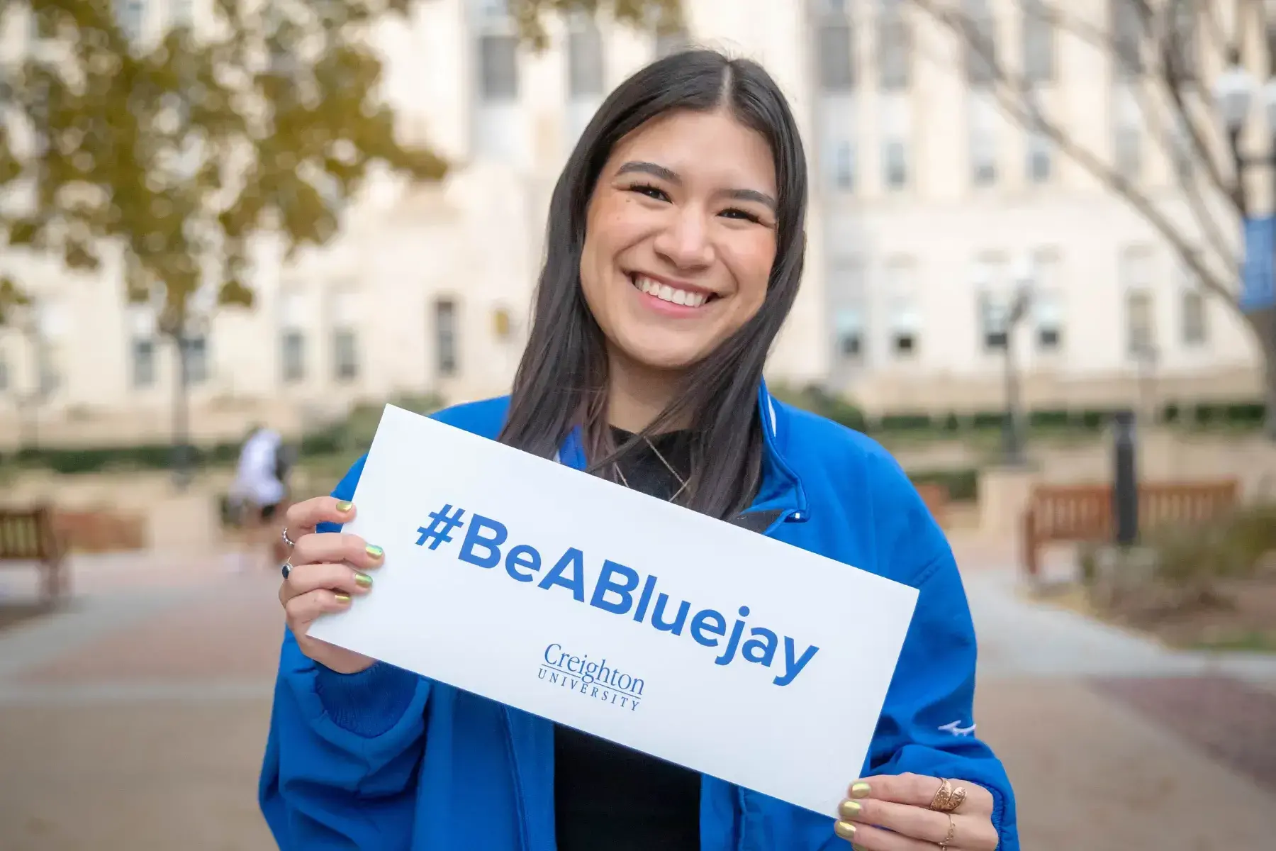 Vanessa holding #BeABluejay sign.
