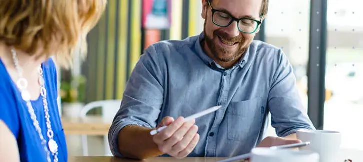 Two adults studying options at home table.
