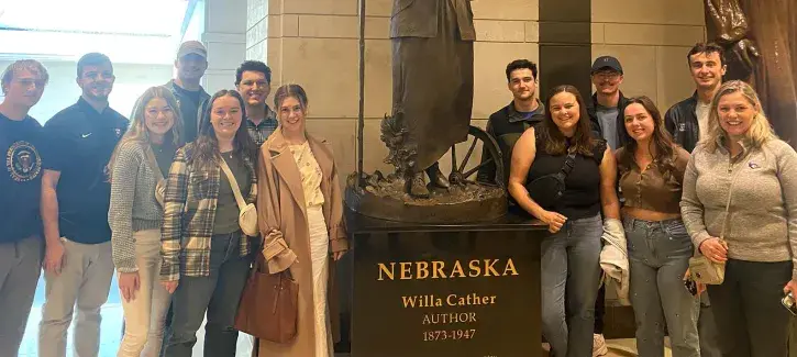 College of Arts and Sciences Dean's Fellows beside Willa Cather sculpture.