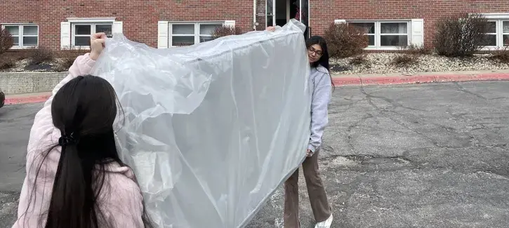 Students assist as refugees begin move-in process.