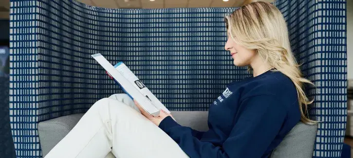 Woman sitting in chair reading book