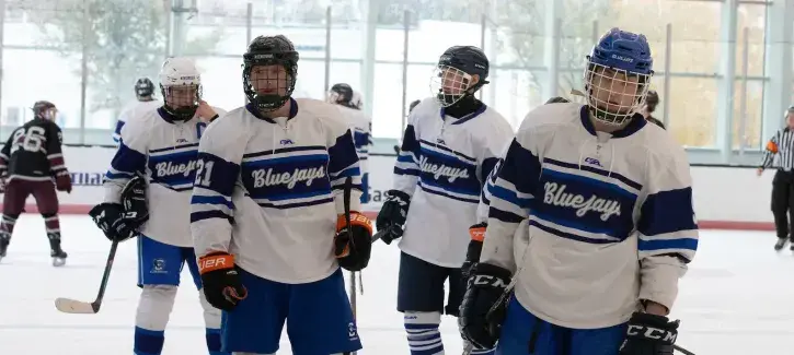 Bluejay hockey players skate to the bench.