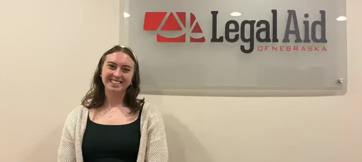 Sarah Crowley standing near Legal Aid of Nebraska sign.