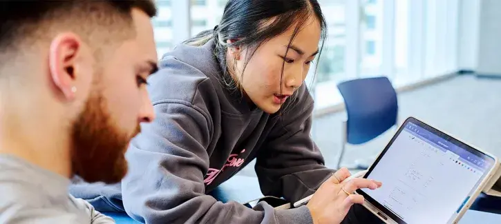 two students working on mobile tablet