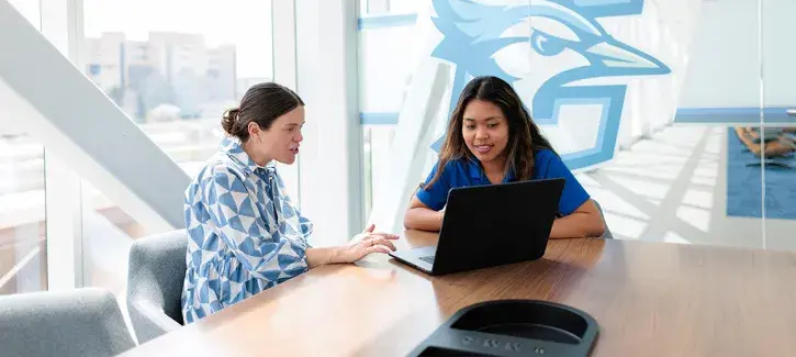 two women looking at a laptop