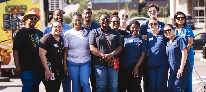 Nebraskans in group shot smiling on sunny day.