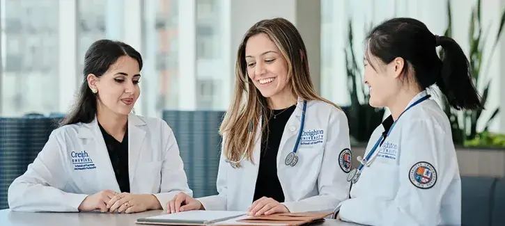 Doctors in white coats talking around a table.