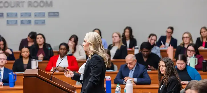 Woman speaker at the podium in student court room.