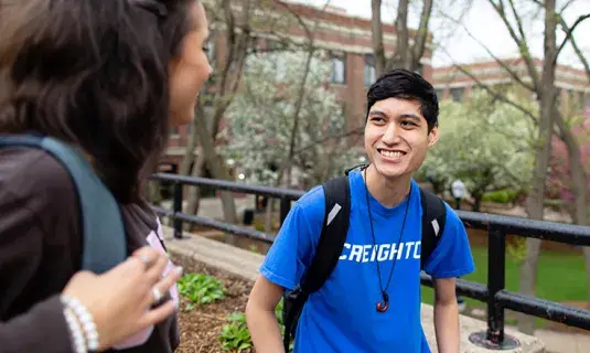 Student in Creighton t-shirt smiling with another student