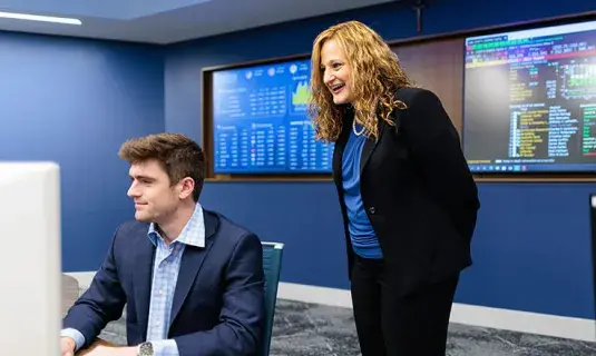 Student in suit on computer with faculty