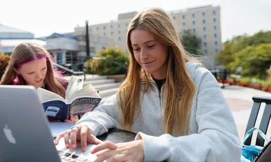 Student working on laptop outside