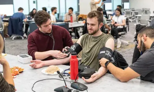 group of medical students practicing taking blood pressure on another