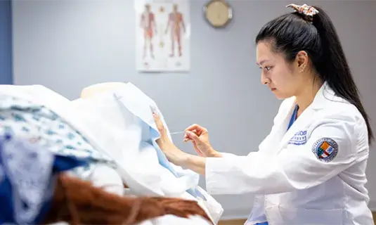 female medical student working on patient