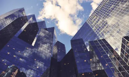 A view of skyscrapers from the ground looking up skyward
