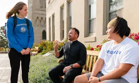 Students talking to clergy on campus.