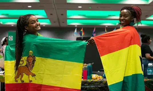 Students showing pride with home country flags.