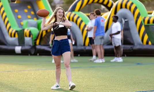 Student throwing football.