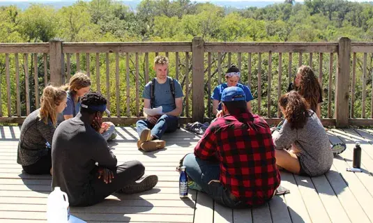 Students talking in a circle outside.