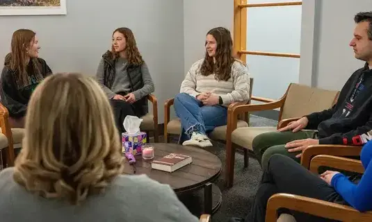 Students sitting in circle talking about their faith.