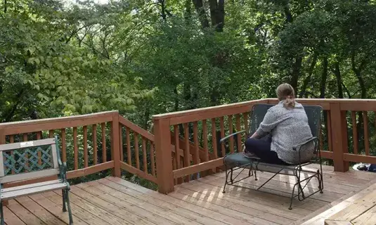 Sole student meditating at Retreat Center on deck.