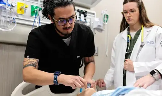 Two health care professionals in patient area.