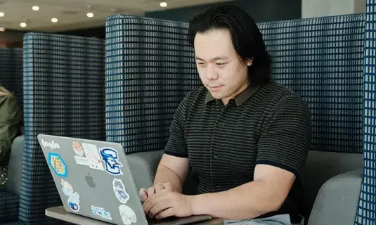 Paramedic studying on laptop.