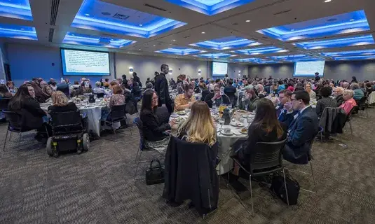 Attendees sit at tables in Mutual of Omaha ballroom.