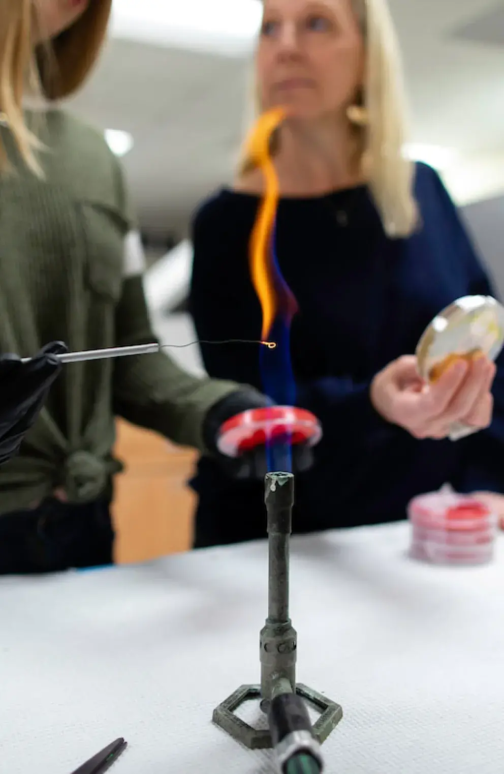 Student and professor working over bunsen burner flame