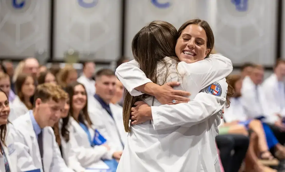 White coat recipients embracing.