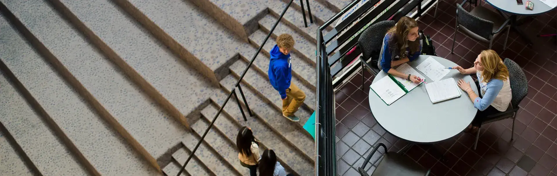 Birds Eye view inside Students Union with students walking and studying.