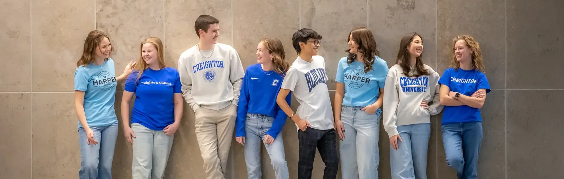 Creighton students gathered against a wall.