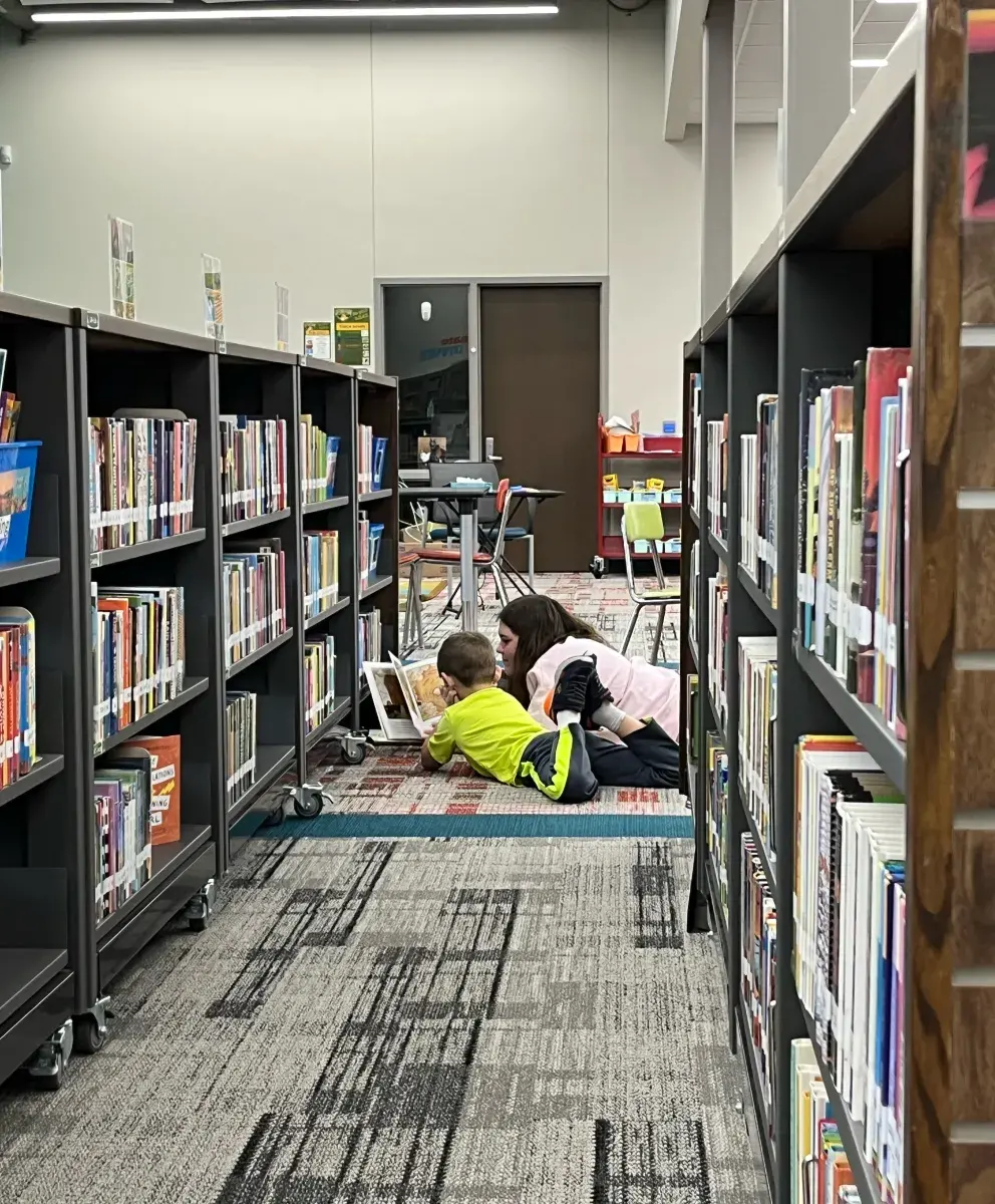 CK Gifford Park volunteer reading with student.