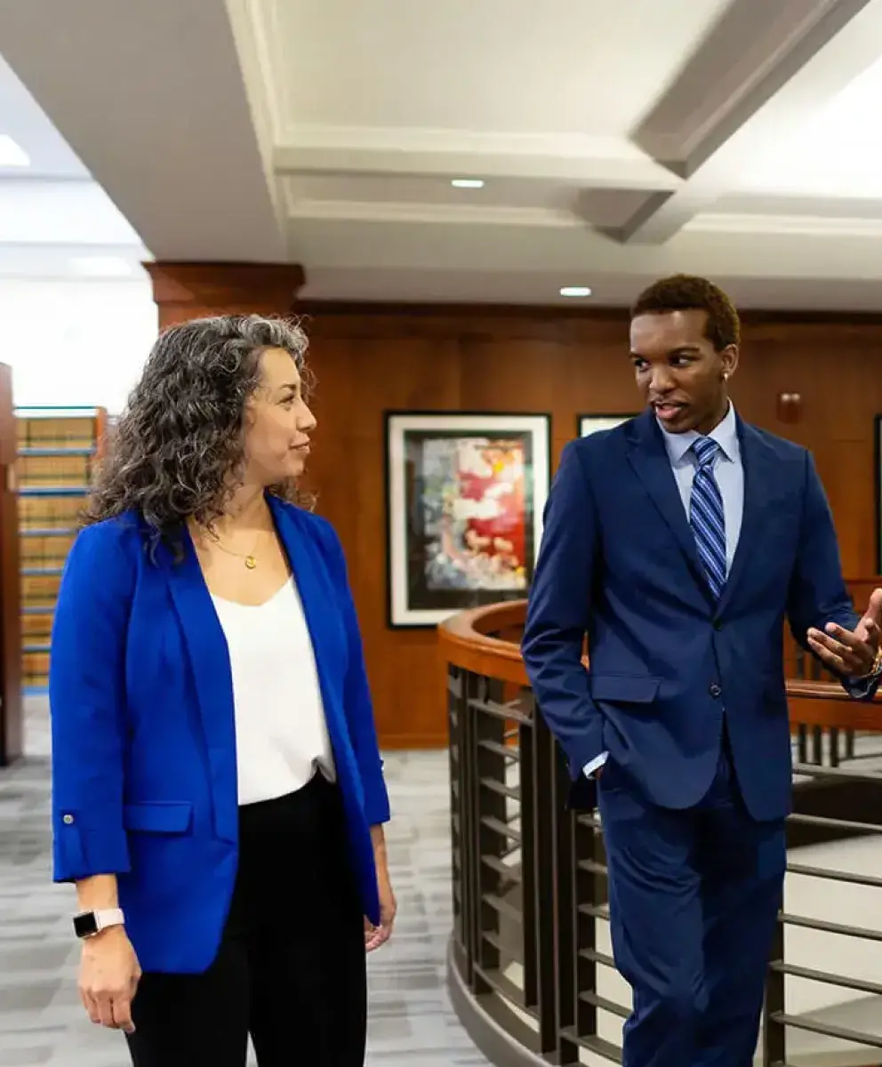 Two people walking and talking in law setting.